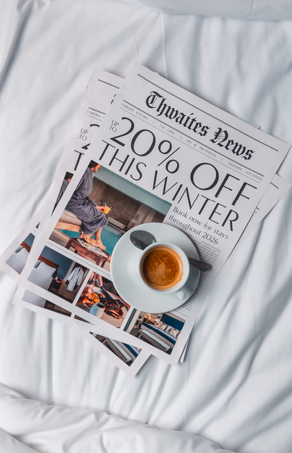"up to 20% off this winter" newspaper with coffee cup on bed